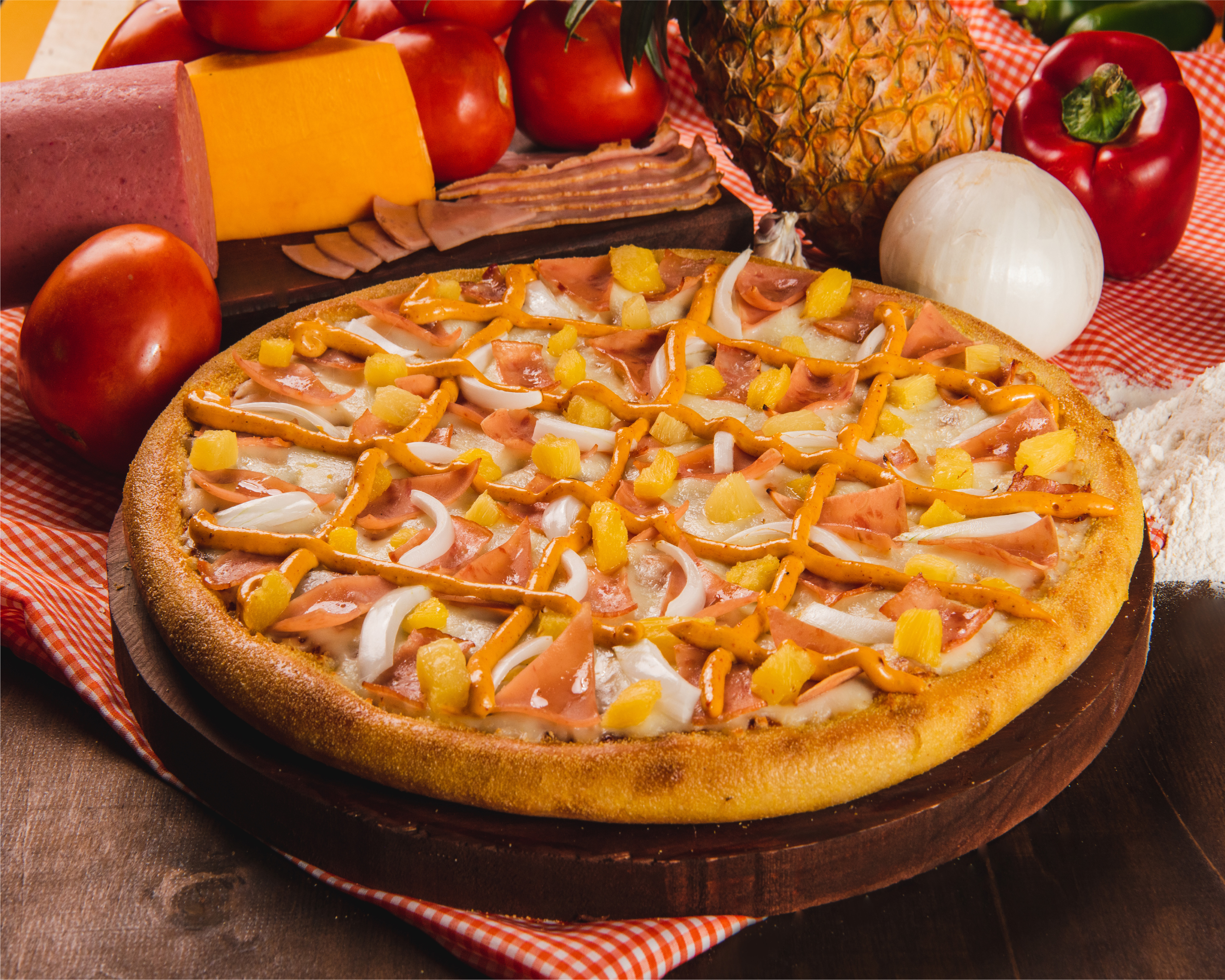 Pizza La Que Sea con jamón, cebolla, tocino, piña y aderezo chipotle